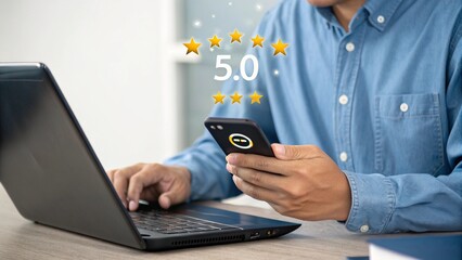 Man Holding Smartphone and Using Laptop with Star Rating Graphic