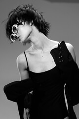 Black and white portrait of a stylish woman wearing sunglasses and a black dress with elegant...