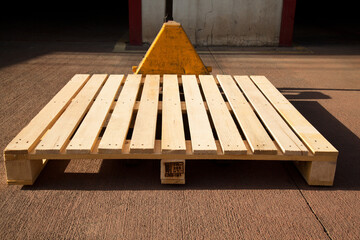 Empty wooden pine pallet with a pallet truck or transpallet in front of a warehouse, logistics and...