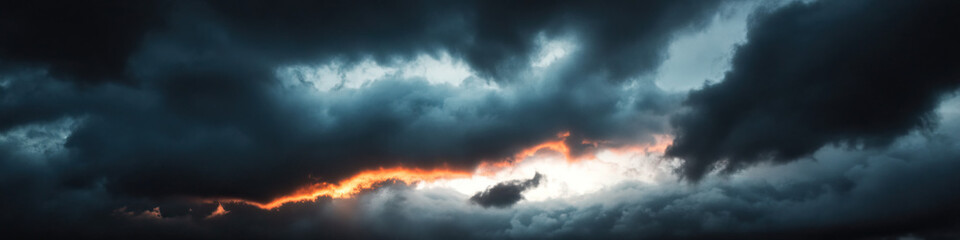 Obraz premium Sunset Light Beneath Dark Cumulonimbus Clouds
