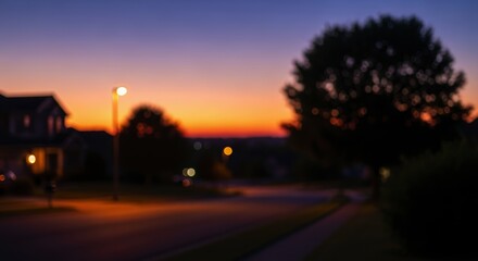 Blurred suburban street at dusk with warm ambient lighting and out of focus elements