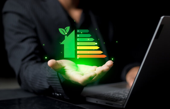 Energy efficiency and green energy concept,man hand holding tablet and looking at house efficiency rating on virtual screen.