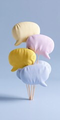 Pastel colored speech bubbles on wooden sticks against a muted blue background
