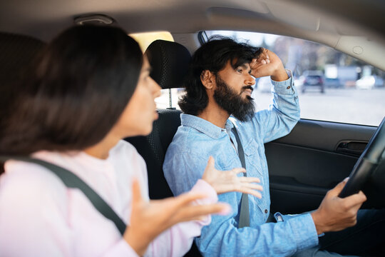 Indian couple arguing inside car, woman speaking while man looks stressed. Scene captures relationship conflict, frustration, tension and emotional communication, closeup