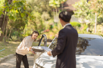 Male insurance agent inspects damaged car after accident and submits claim documents from insurance...