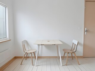 Minimalist interior featuring a light wood table and two chairs against a white wall and wood floor