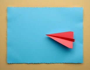 A red paper airplane on a blue paper background with a tan background in a studio shot overhead view