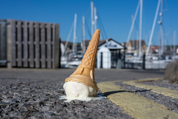 a dropped ice cream cone melting on a sunny road