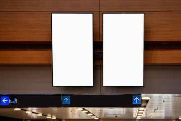 Two blank vertical digital advertising screens indoors, ideal for mockups or commercial display...