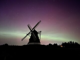 old windmill at night with aurora and northern lights