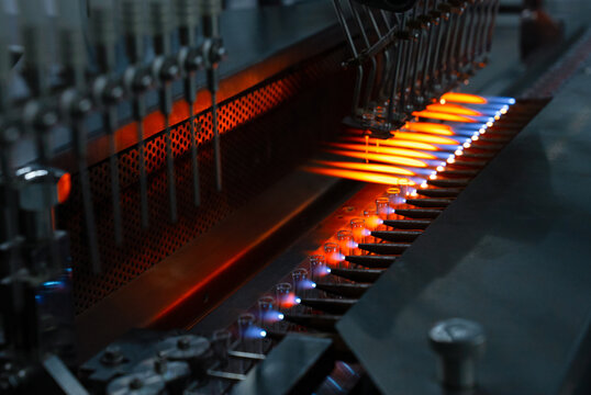 ampoule making process using fire in vaccine pharmaceutical production factory. glass tubes for vaccine manufacturing factory. ampoule manufacturing line. pharmaceutical vaccines. ampoules making