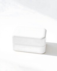 Minimalist white box on white surface with soft shadows and textures