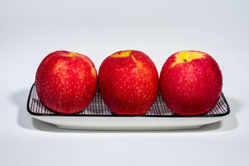 Maçãs vermelhas fresquinhas na bandeja, sabor, cor e saúde.
