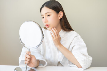 Expression worry asian young woman hand touching pustule around the chin and mouth, allergic when...