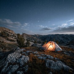 Illuminated Tent Under Starry Night Sky in Rocky Mountain Wilderness