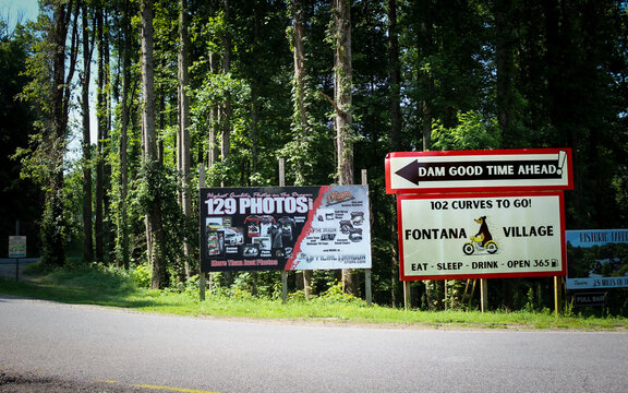 Fontana Dam, NC (USA) - July 5, 2025: Signs directing motoris towards Fontana Village and advertising for The Dragon U.S. Route 129 photos. For Editorial Use.
