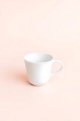 Simple composition featuring a solitary white cup on a soft pink backdrop