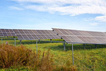 Rows of solar panels for electricity generation in the countryside on a clear autumn day