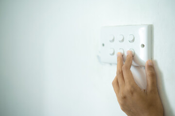 Close up of hand of woman turn off on lighting switch at home room. Finger pushing light switch...