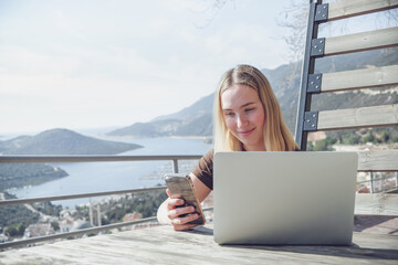 Remote Work,digital nomad enjoys remote work with a laptop in a scenic mountain setting.freedom of location-independent work, online business, and the balance of work and travel.