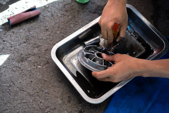 Mechanical cleaning and repair of scooter motorcycles (CVT). Wiping with a brush to remove hard-to-reach dust. Concept of motorcycle repair, maintenance and service.