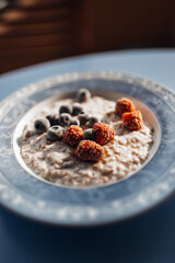 Bowl of Porridge with Fresh Berries on Table