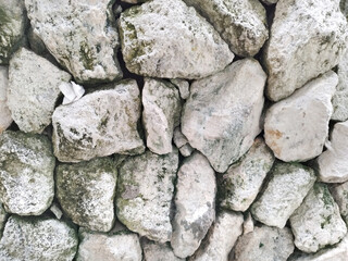 Close up of natural random cut light grey and white cobble stone flattened on a surface. Rough flagstone and gravel stacked randomly and cemented, for floor or wall finishes. Seamless background