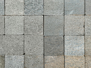 Close up of flat andesite slate stone or grey paving stone. Suitable for wall finishes, cladding, or outdoor floor materials. Good for pavement and sidewalk. Seamless background texture.