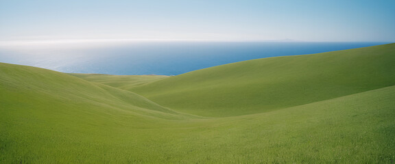 Obraz premium Undulating Green Hills Overlooking the Deep Blue Ocean Under a Clear Sky