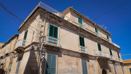 Traditional architecture in Tropea, Italy, featuring an old residential building with green...