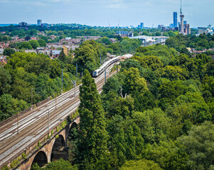 Hanwell train station in London with classic Victorian architecture, platform canopy, and railway tracks under a clear summer sky