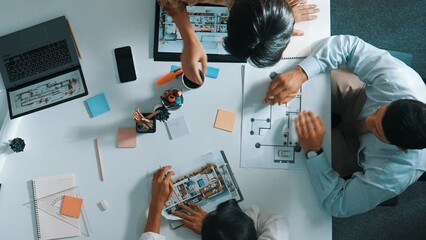 Architect team discussing and pointing and presenting blueprint to interior designer. Aerial view professional business people brainstorming building interior at table with house model. Alimentation.