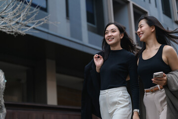 Two young businesswomen walking and talking in the city