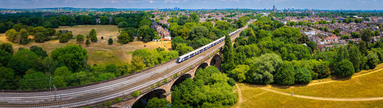 Hanwell train station in London with classic Victorian architecture, platform canopy, and railway tracks under a clear summer sky
