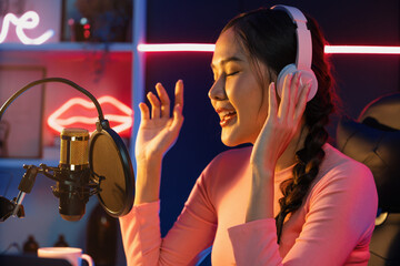 Host channel of young beautiful Asian broadcaster listening the music on social media with...