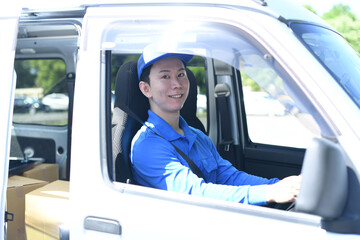屋外で運転するアジア人男性の配送スタッフ