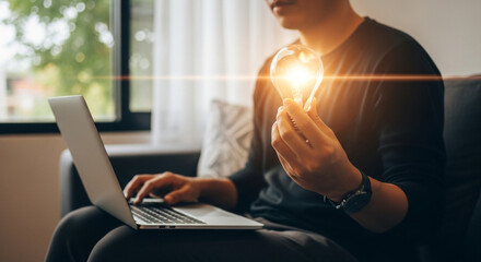 A glowing light bulb in a man's hand captures the essence of bright ideas, innovation, and sustainable inspiration in business.