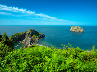 San Juan de Gaztelugatxe in Bermeo, Spain, rises from the Bay of Biscay with a winding stone...