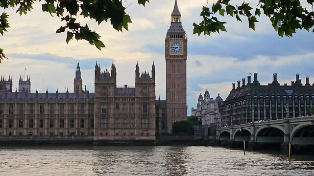 British Houses of Parliament across the Thames with Big Ben, Westminster Bridge and dancing leaves, London, UK