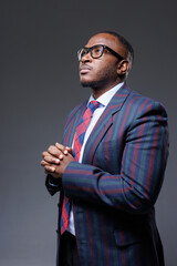 Successful African Businessman in Stylish Glasses and Suit with Hands Together, Leadership Portrait