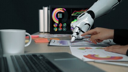 A futuristic scene showing a robotic hand aiding a human in analyzing colorful graphs and charts on...