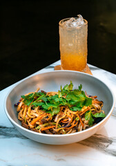 Asian beef udon noodles with vegetables, sesame, and fresh cilantro. Served with iced orange...