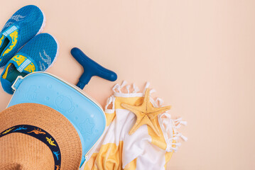 Children's beach essentials including a hat, suitcase, shoes, towel, and starfish.