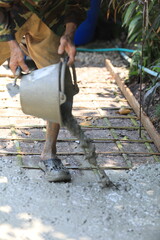 Cement pouring on steel rebar grid during construction, cement pouring close-up with wet texture in daylight, cement pouring on reinforced foundation floor