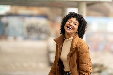 Happy african american woman laughing outdoors in the city
