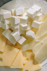 White Feta Cheese Cubes with Yellow Cheese Slices on Plate