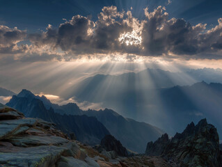 Sun rays breaking through clouds over rocky peaks