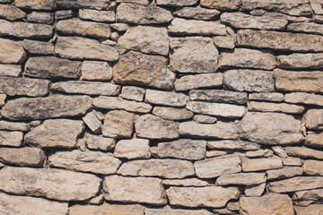 Rustic stone wall showcasing unique textures and earthy tones, blending harmoniously with natural surroundings