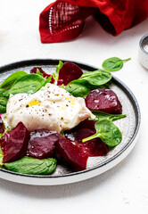 Fresh salad with italian burrata cheese, beetroots, spinach and olive oil, top view