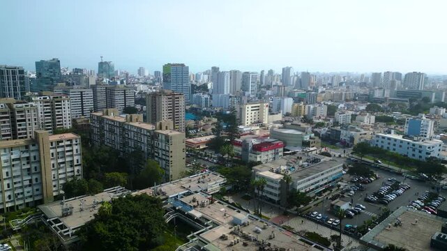 Vuelo de dron sobre la residencial San Felipe con vistas a la gran ciudad de Lima en una tarde de invierno.